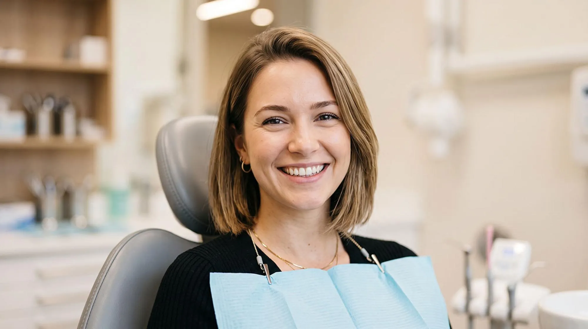 Female dental patient smiling with new dental crown